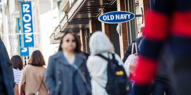 People walking past an Old Navy store front