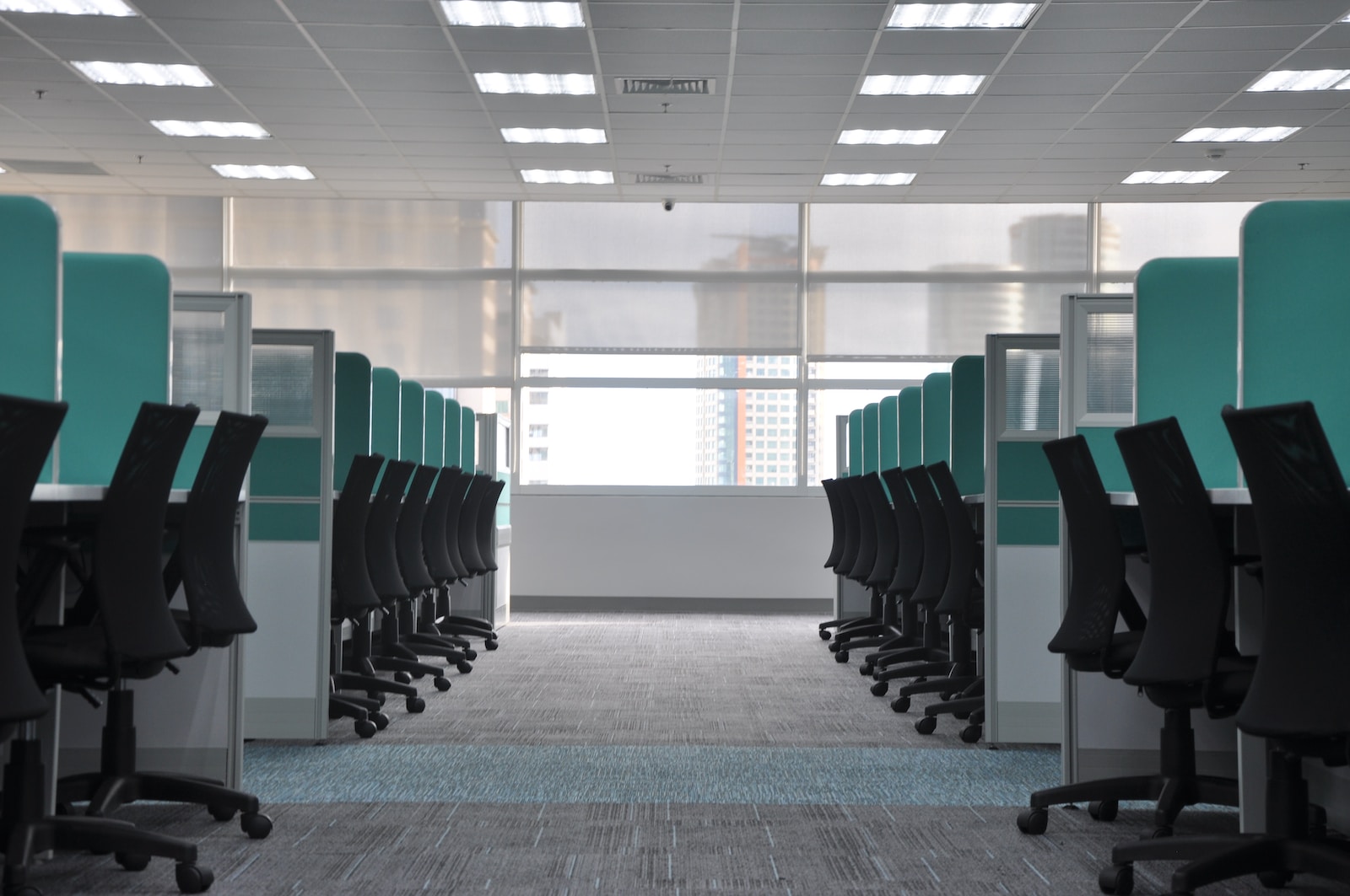 empty black rolling chairs at office cubicles