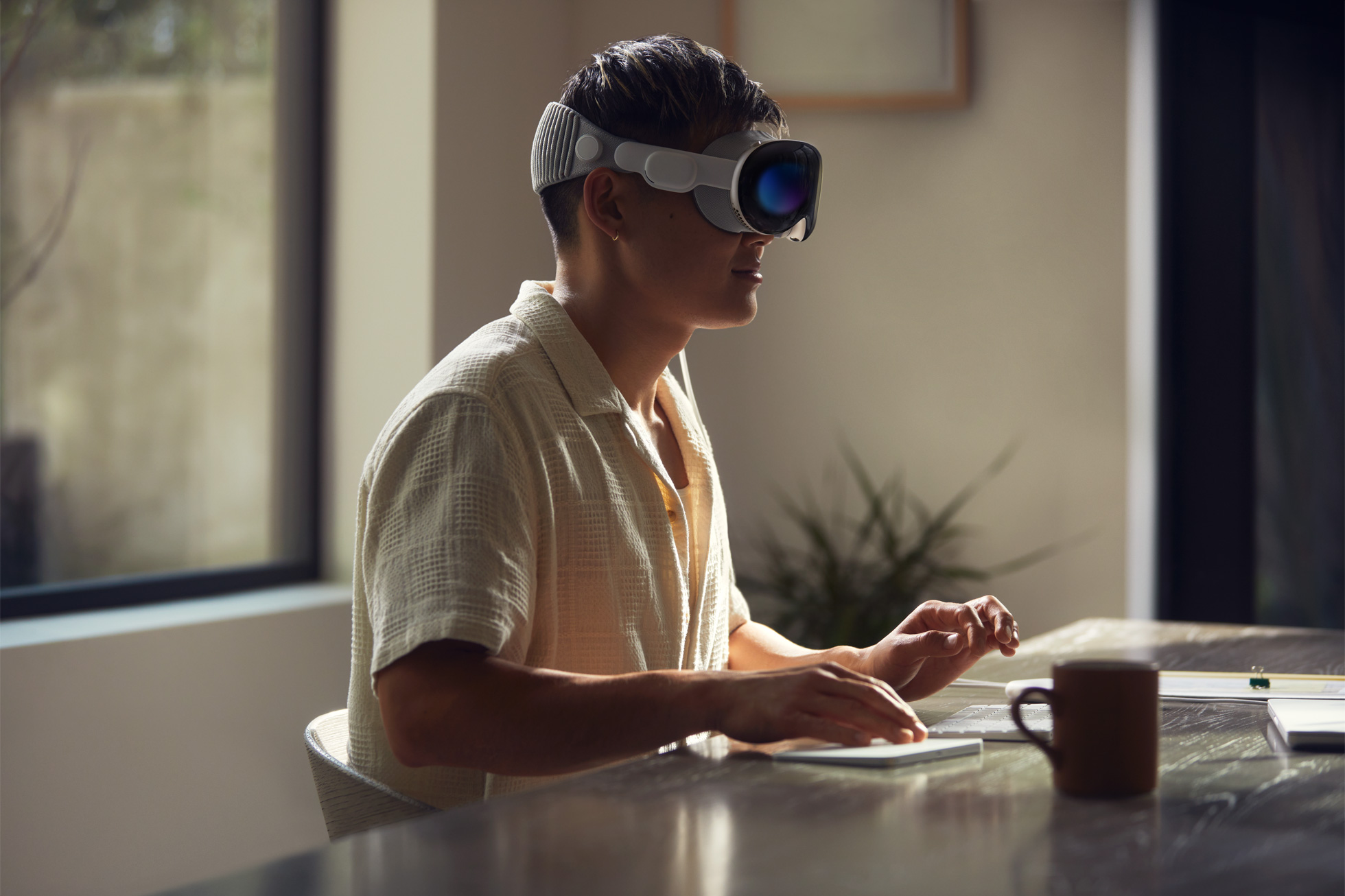 Man wearing Apple's Vision Pro VR headset while working