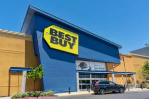 Best Buy store entrance, facade and exterior with customer car parked in front