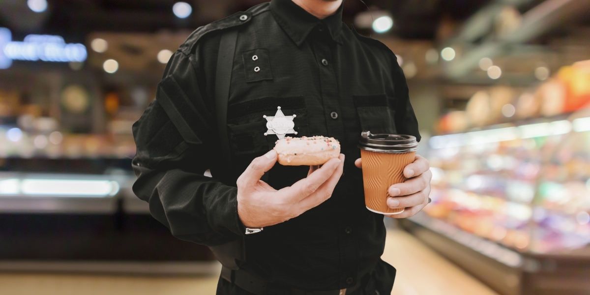 A police officer holding a donut and coffee