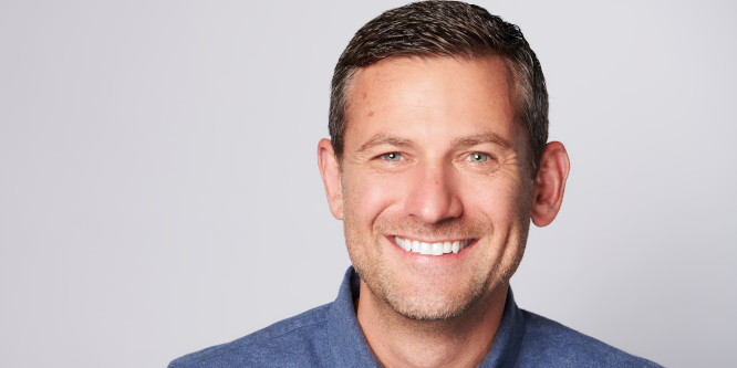 Photo of Matt Baer, incoming CEO, Stitch Fix, smiling against light gray background wearing blue collar shirt