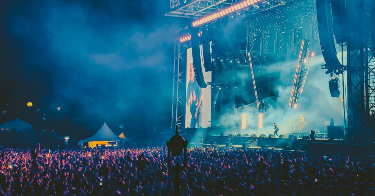 A concert stage with concertgoers in the audience