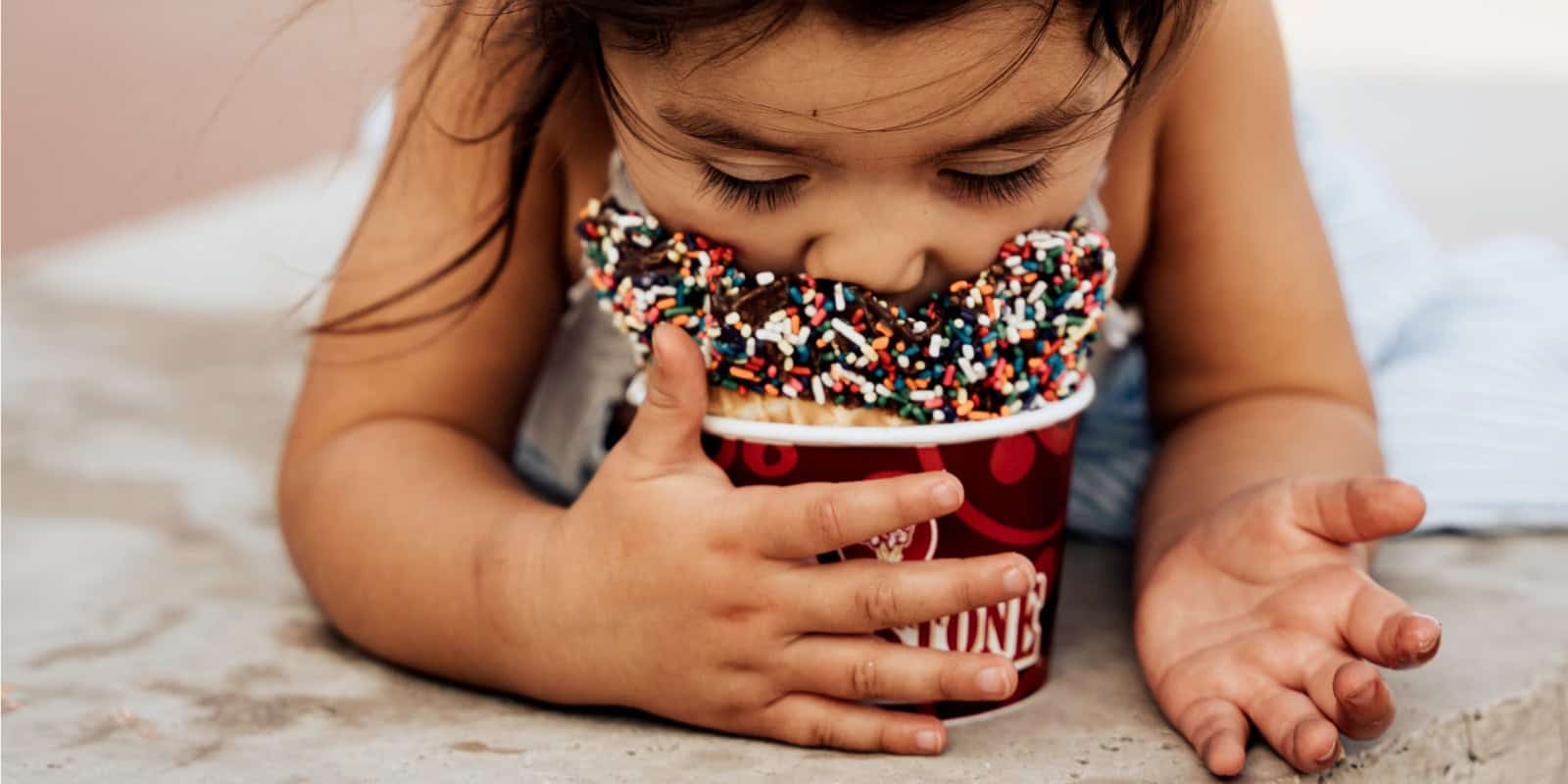 a photo of a child eating ice cream from cold stone creamery
