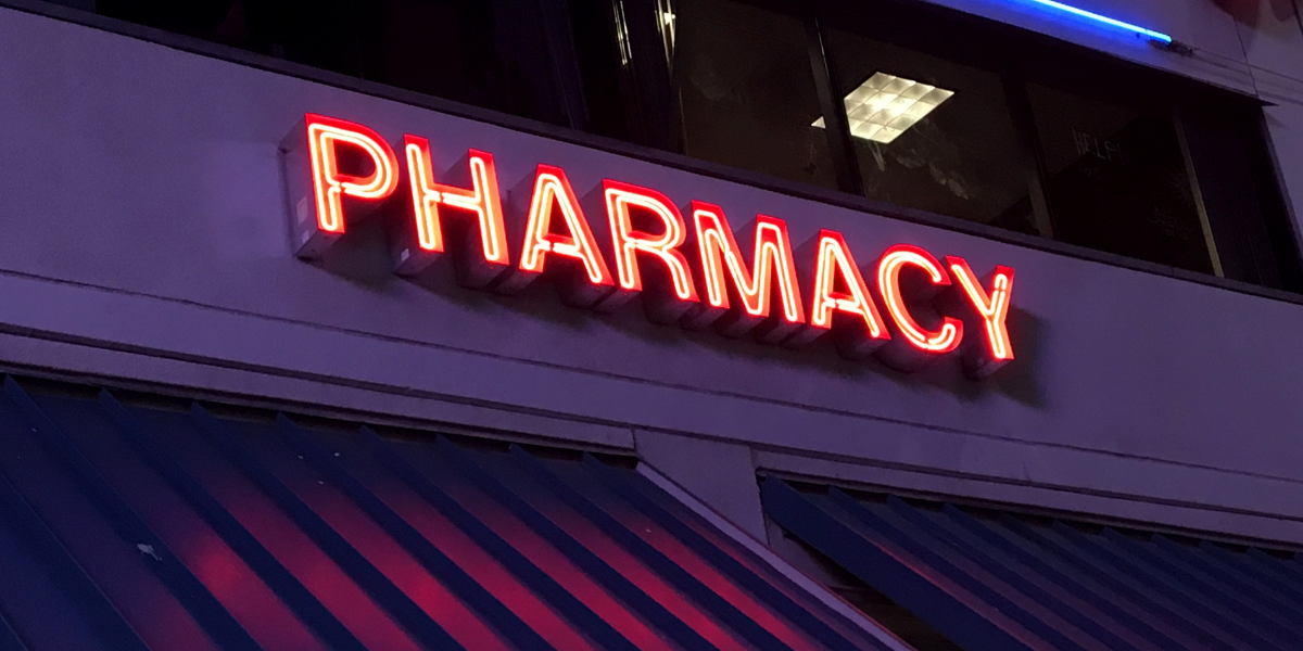 Lit-up sign on a building that says "Pharmacy"