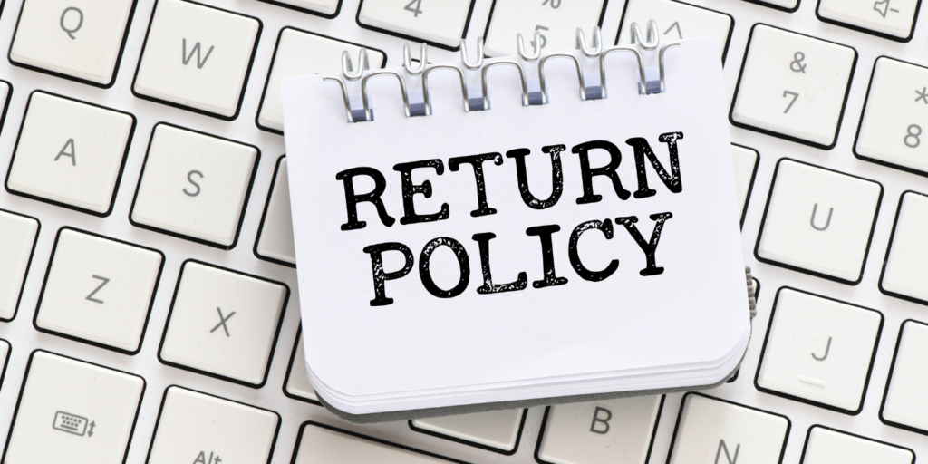 The words "Return policy" on a journal on top of a keyboard