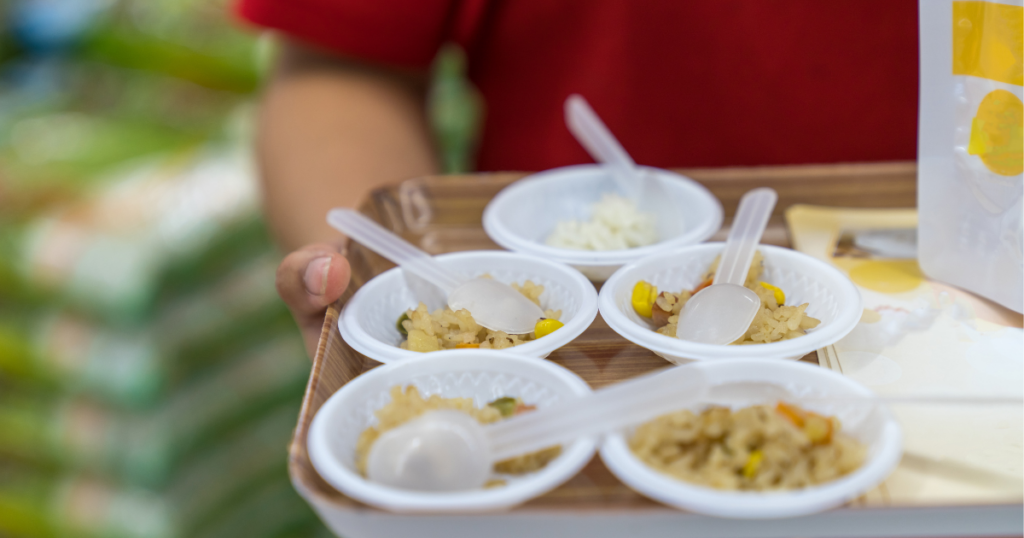Person holding a tray of small samples of food