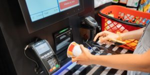 Person scanning items at self-checkout