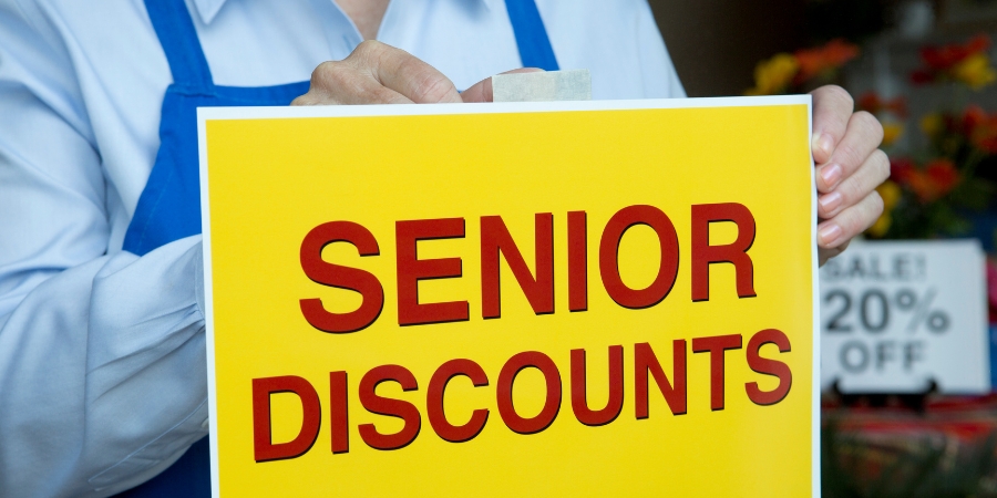 Employee hanging a sigh that says "senior discounts"