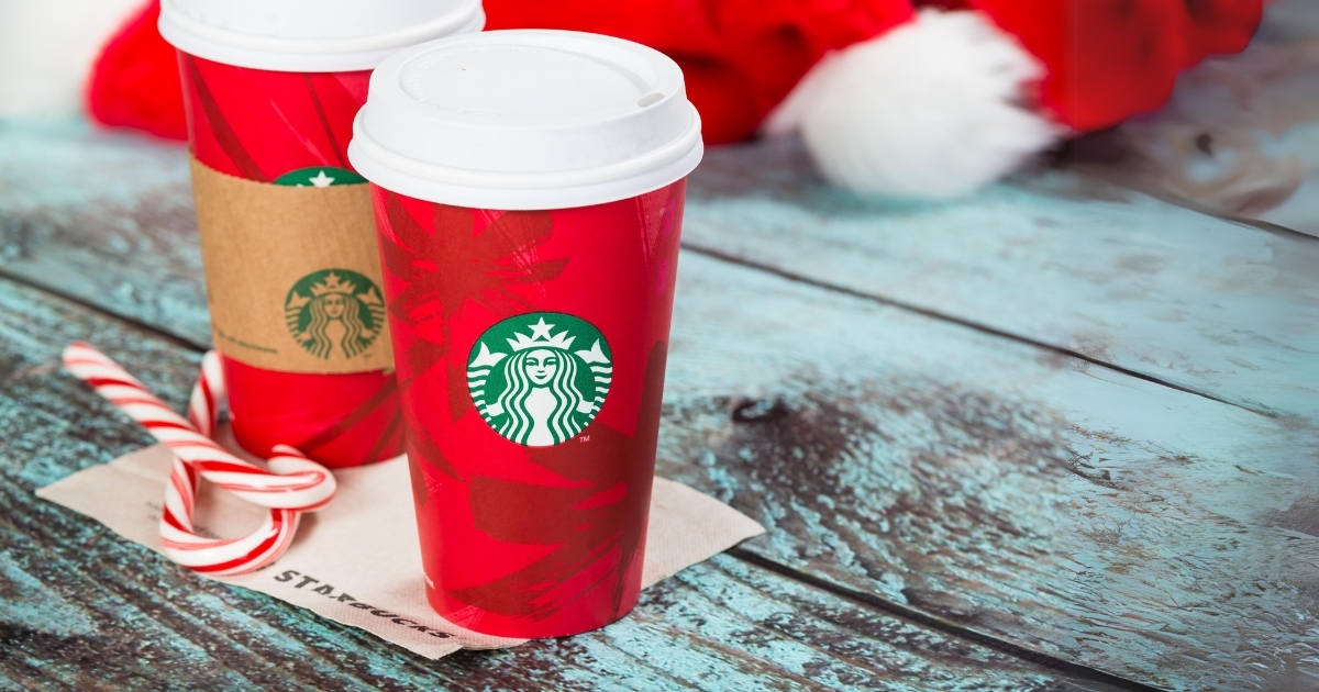 Red Starbucks cups next to candy canes
