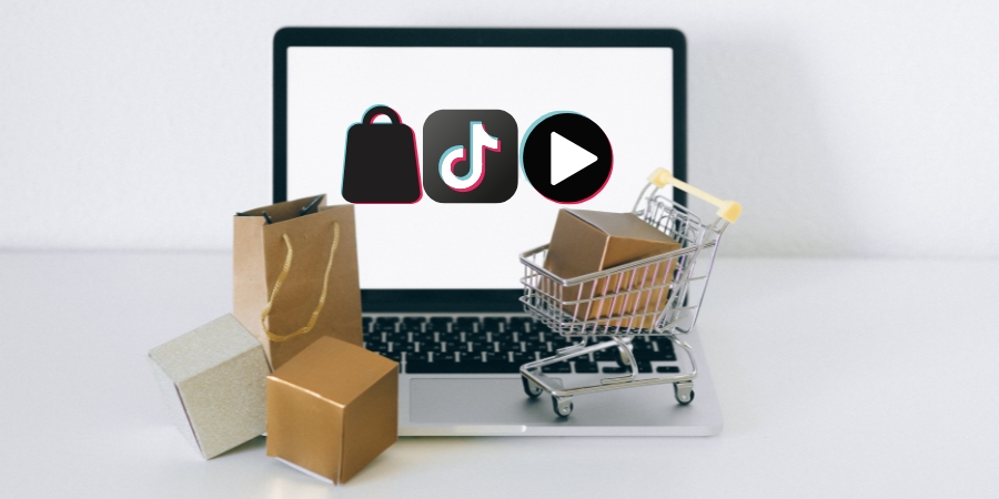Small shopping cart and shopping bag and boxes on top of a laptop, which shows the TikTok logo