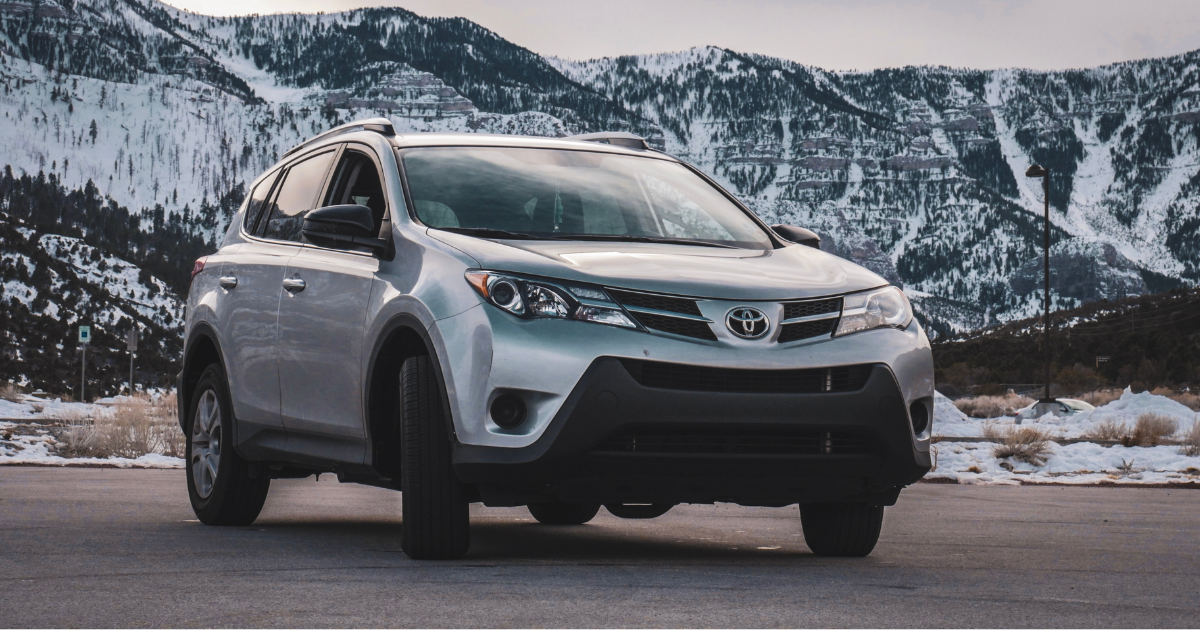 Image of a Toyota with snowy mountains behind it