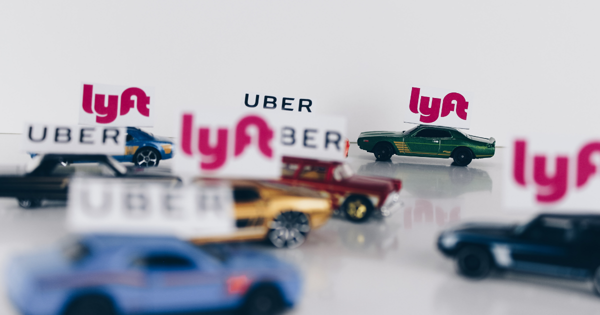 Fake cars with the words "Uber" and "Lyft" over them