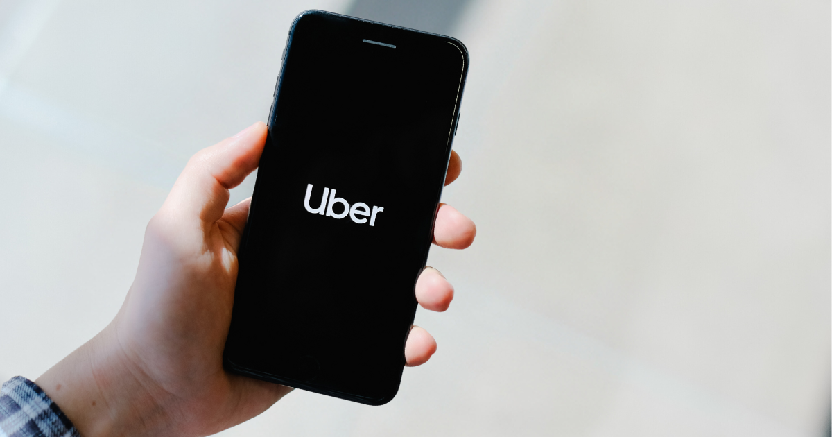 Person holding a phone with the "Uber" logo on it