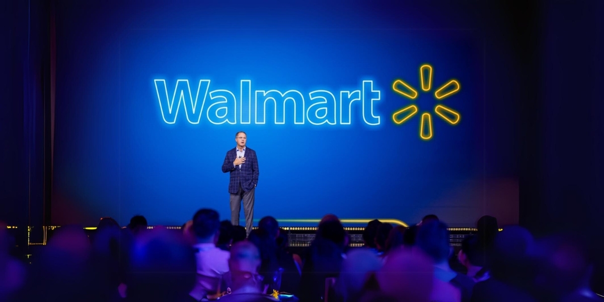 Speaker in front of a screen that says "Walmart"