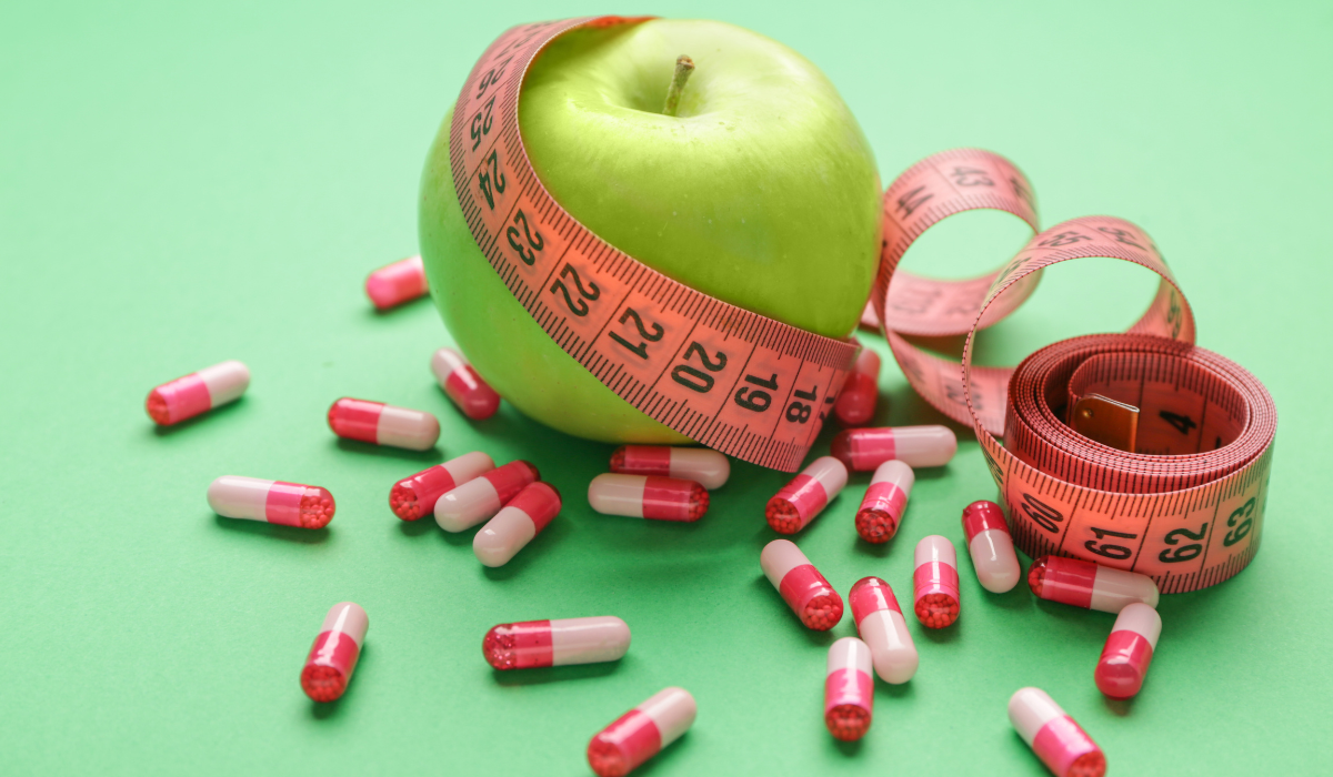 Weight loss drugs, apple, and measuring tape