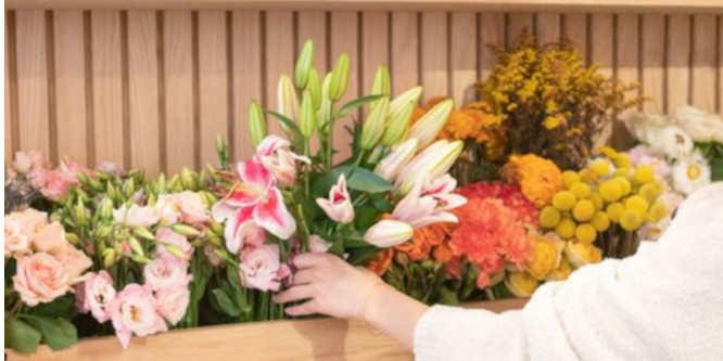 hands arranging flowers at Bouqs, a California flower retailer