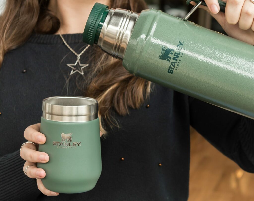 a woman is holding a cup and a water bottle