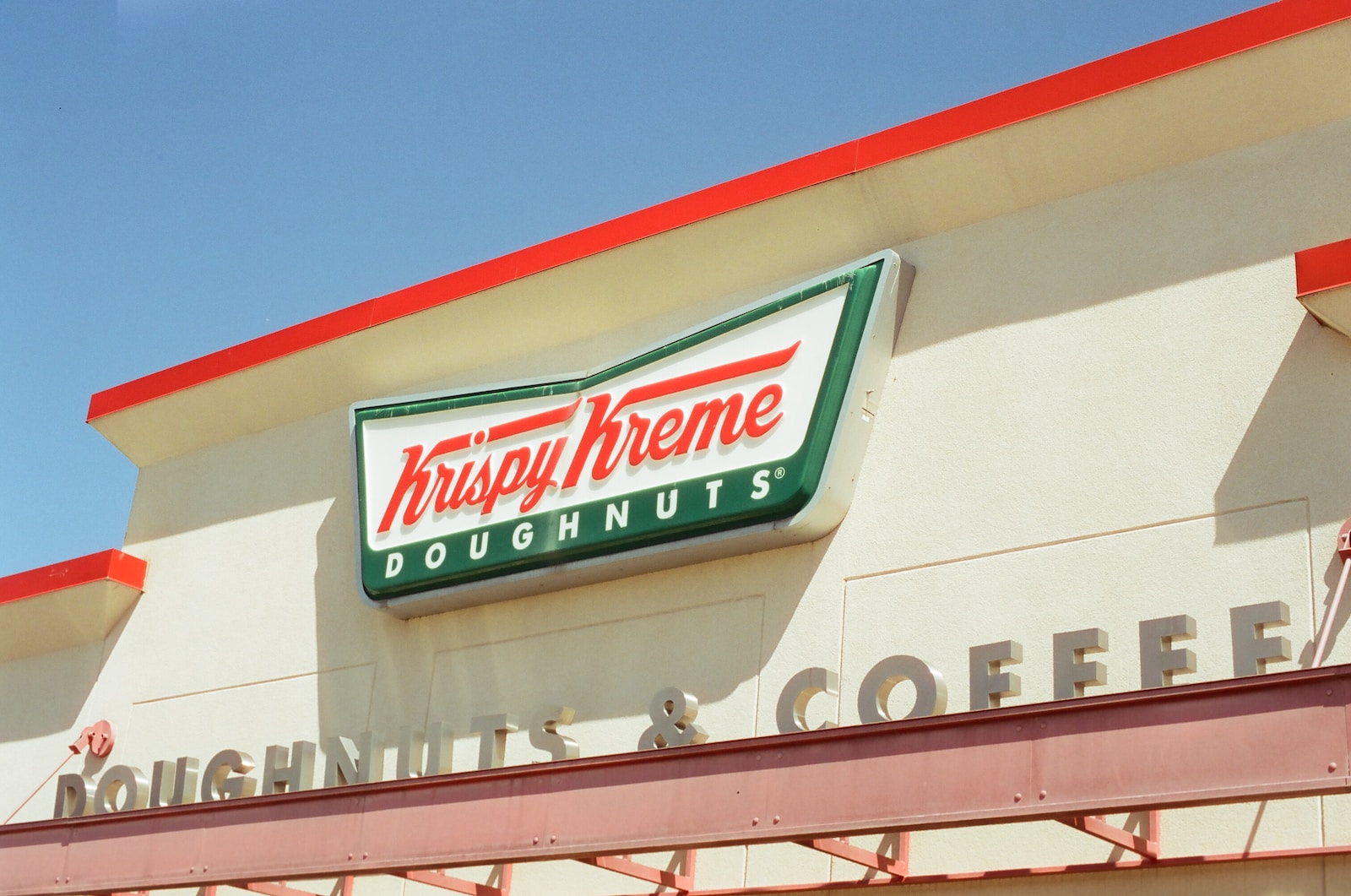 a krispy kreme doughnuts sign above a doughnut shop