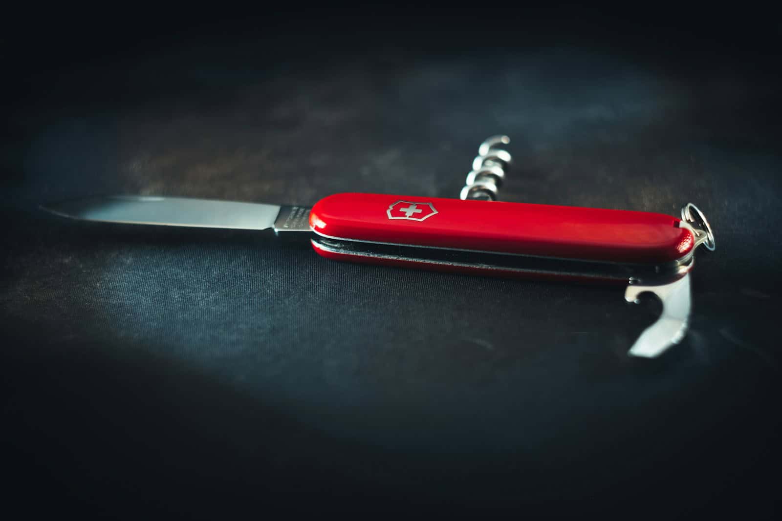a red pocket knife sitting on top of a table