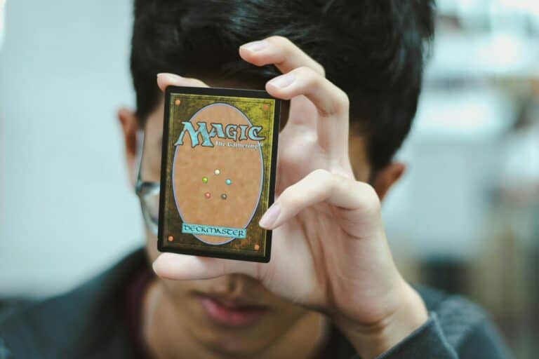 boy holding Magic: The Gathering trading card hasbro
