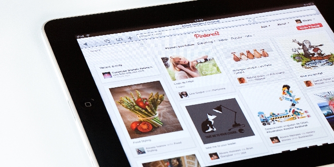 High angle view of an Apple iPad2 displaying Pinterest homepage on a desk. Pinterest is a pinboard-style social photo sharing website that allows users to create and manage theme-based image collections. iPad, the digital tablet with multi touch screen produced by Apple Computer, Inc."