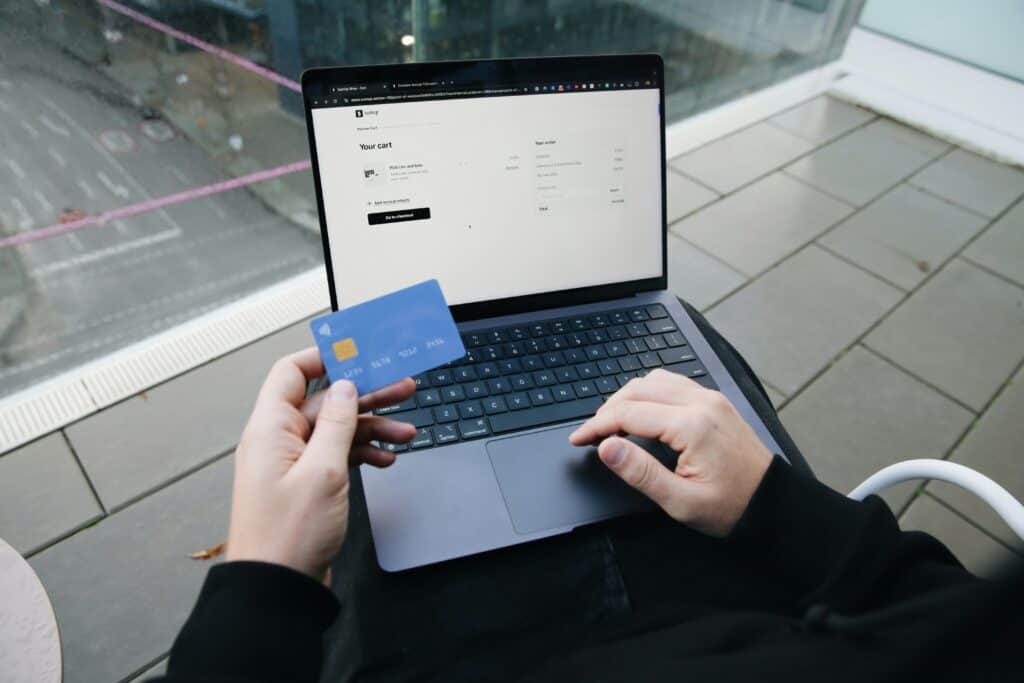 laptop and person holding credit card shopping online