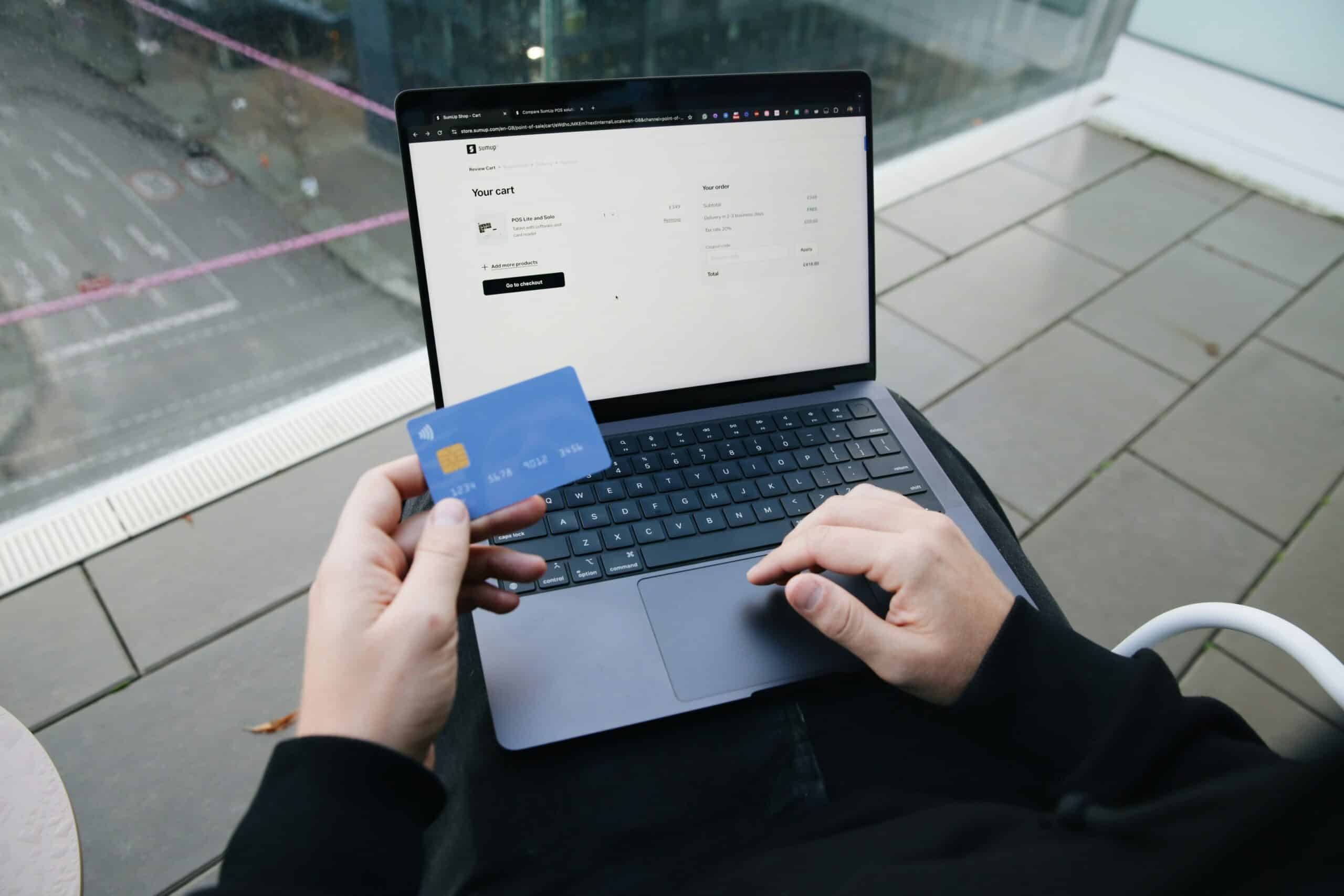 laptop and person holding credit card shopping online
